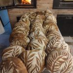 fournée de pain devant le four à bois